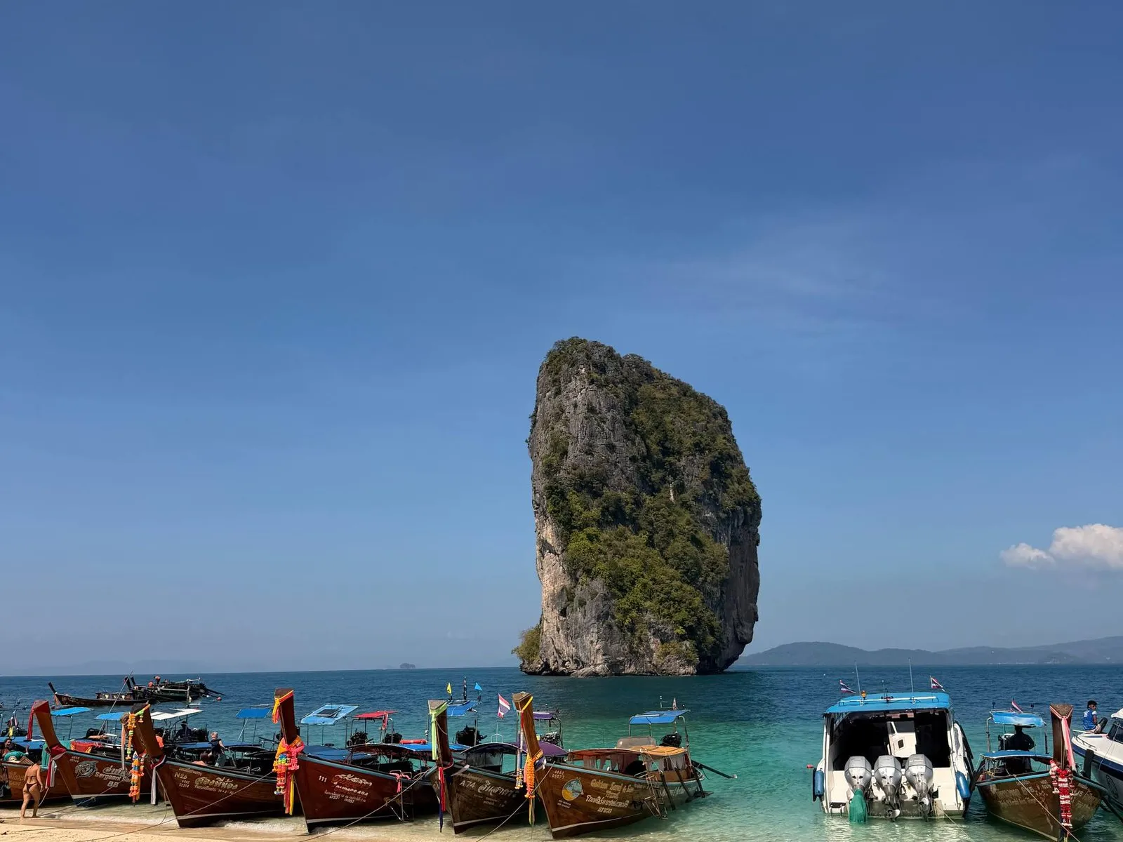 Poda Island con la sua torre calcarea e le barche longtail vicino a Krabi, Thailandia.