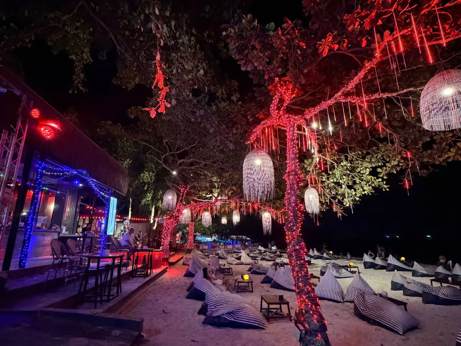 A beach bar lit up at night in a Thai tourist town.